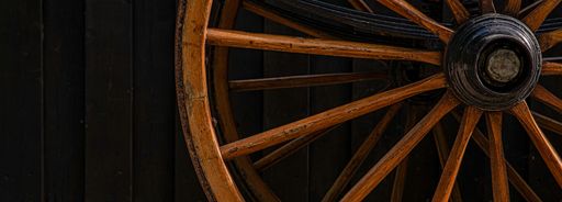 A close-up shot of a wooden wheel of a horse carriage