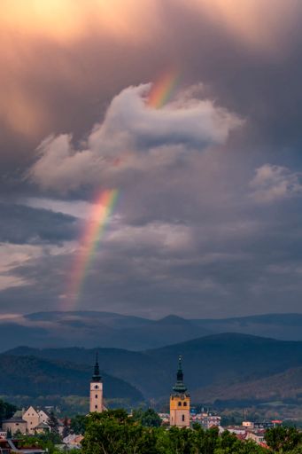A dramatic sunset with beautiful rainbow over Banska Bystrica city in central Slovakia, vertical shot