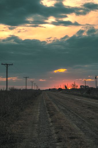 A vertical shot of beautiful sunset in an empty rural road