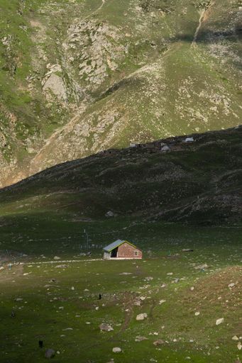 A vertical shot of a beautiful cottage on the hill landscape