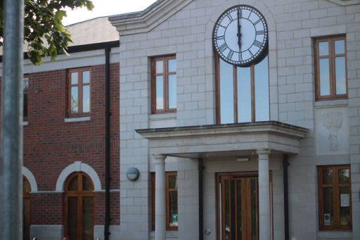 The old marble and brick designed building with a round clock above the entrance