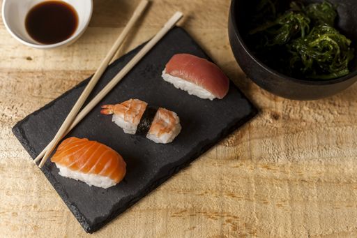 A high angle shot of salmon nigiri sushi on a wooden table