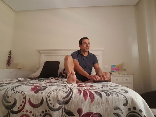 Man chatting and typing with someone in the bed