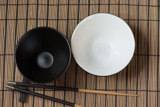 A top view of black and white bowls and a chopstick - Thai kitchenware