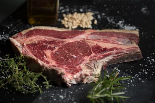 A shallow focus shot of a raw steak seasoned and ready to be cooked