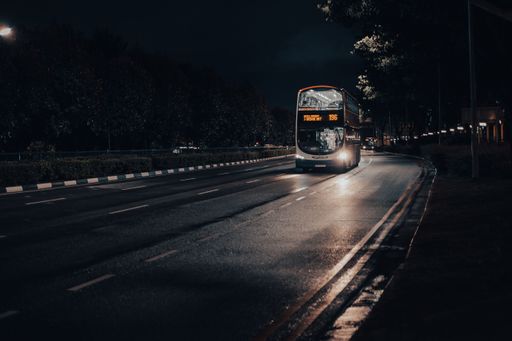 A vertical shot of a bus on the road driving to the Bedok Interchange at night