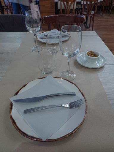 A high angle shot of the empty plates with cutlery on a wooden table in the cafe