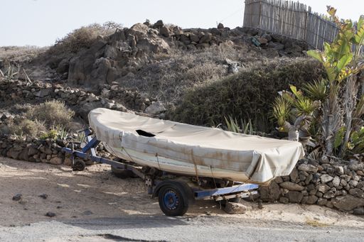 A boat on the wheels  in the rural area during daytime