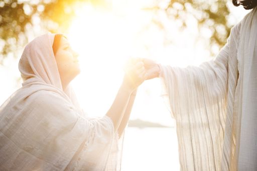 A female wearing a biblical robe and grabbing the hand of Jesus Christ for help and guidance