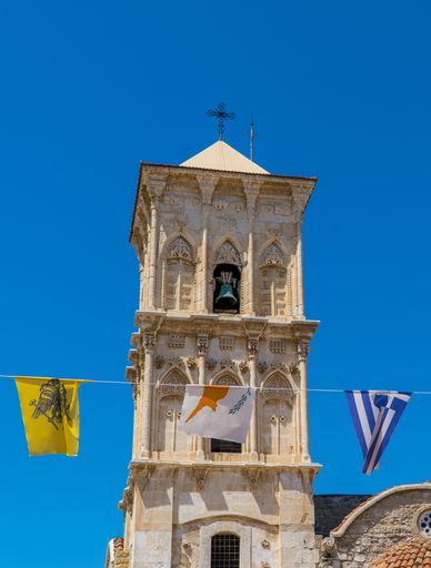 A vertical shot of Greek and Cyprus flags in front of St. Lazarus Church in Larnaca, Cyprus