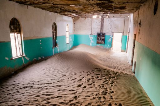 A high angle shot of white sand inside on an abandoned building