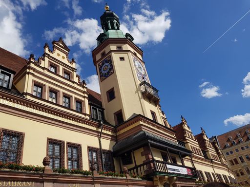 A low-angle shot of the Old City Hall of Leipzig, Germany against the blue summer sky with clouds