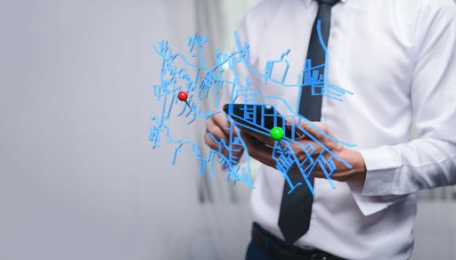 A closeup of a person holding a phone in the background of an illustrative city map