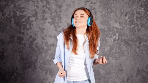 A caucasian female with headphones enjoying music in a studio