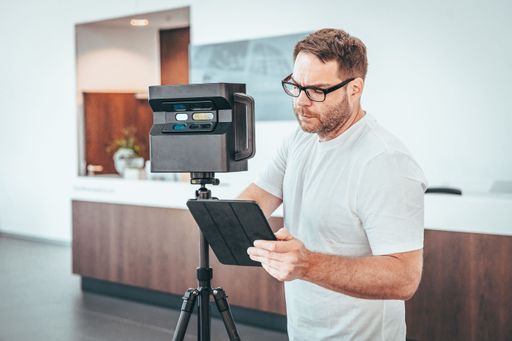 A Caucasian man with Matterport camera and Tablet doing 3d Scan Virtual Tour indoors