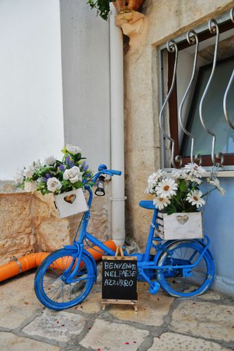 "Welcome to the blue village" is written on a bike in a small street in Casamassima.
