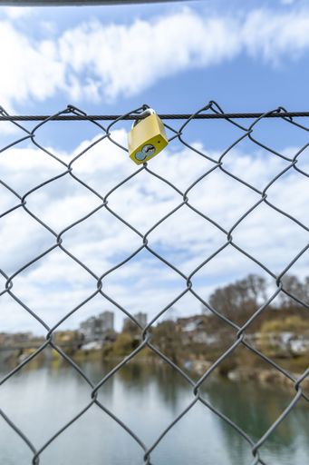 Landscape from the bridge with a padlock over the river on sunny day under blue cloudy sky