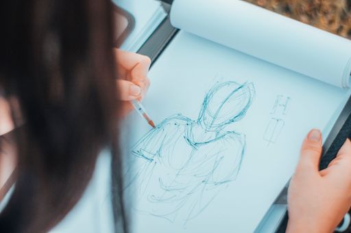 A closeup shot of a sketchbook with a drawing of a figure.