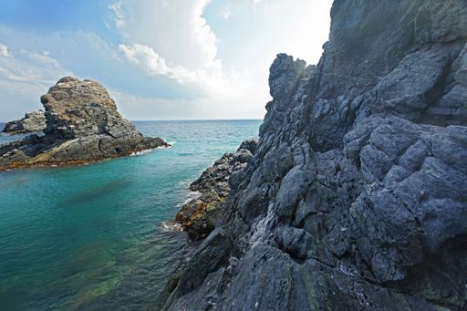 A breathtaking scenery of a seashore with big rocks under the clear blue sky in Spain, Almunecar, cliff San Cristobal