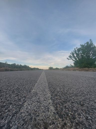 A long cement road on a cloudy day