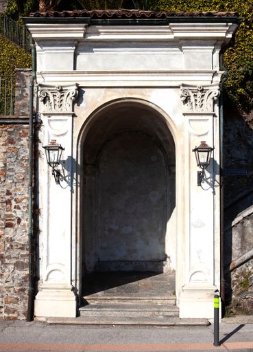 A vertical shot of the beautiful antique arch made of white stone.