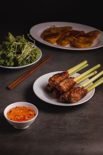 A vertical shot of Vietnamese food on a black table