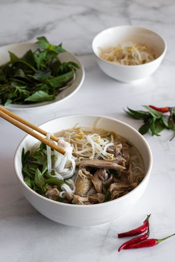 A vertical shot of soup Pho Bo with sticks in it, Vietnamese food, Vietnamese cuisine