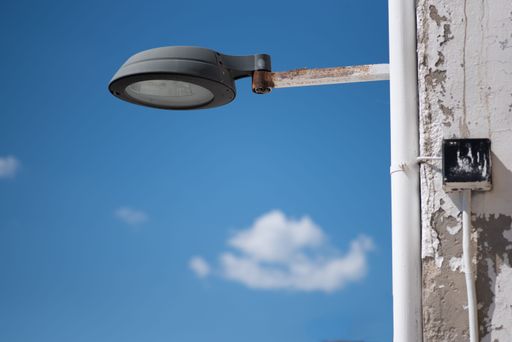 A closeup under view of round street lighting with blue sky in the background