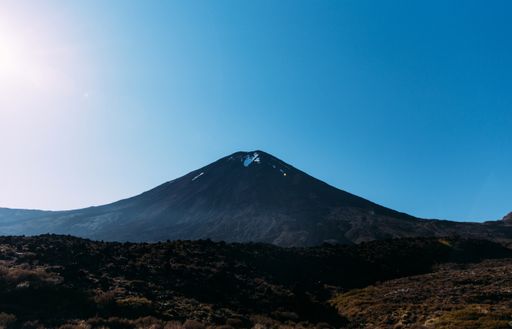 A beautiful shot of a rocky landscape with hills on the background under a blue sky