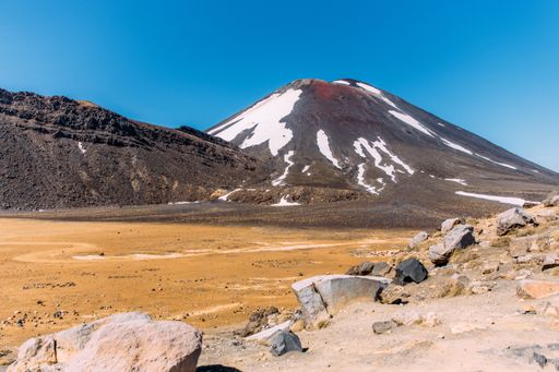 A beautiful shot of a rocky landscape with hills on the background under a blue sky