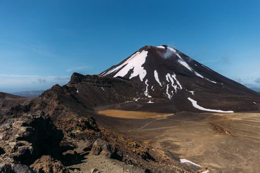 A beautiful shot of a rocky landscape with hills on the background under a blue sky