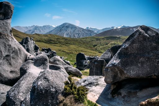A beautiful shot of a rocky landscape with hills on the background under a blue sky
