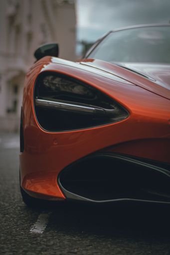 A vertical shot of an orange Mclaren 720s found roaming the streets of London