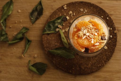 An overhead shot of oranges with oatmeal in a glass on the table