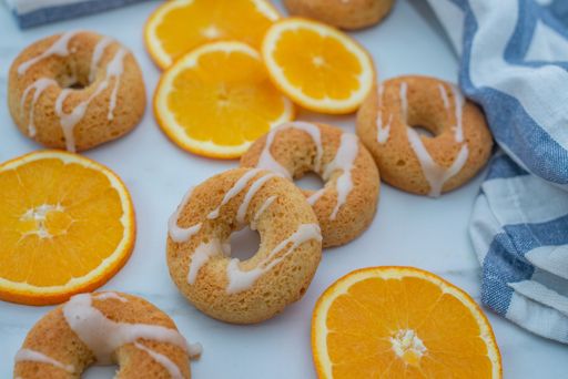 A closeup shot of the oranges and donuts on the table