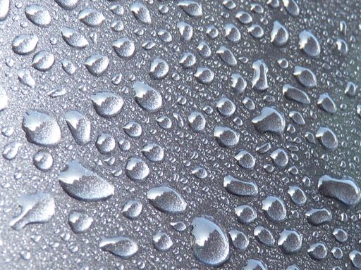 A closeup shot of waterdrops on a gray surface