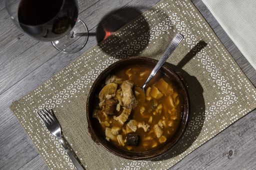 A high angle shot of a delicious dish with meat on a brown tablecloth