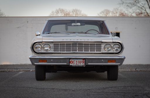 A restored old car after being cleaned and polished in the parking lot