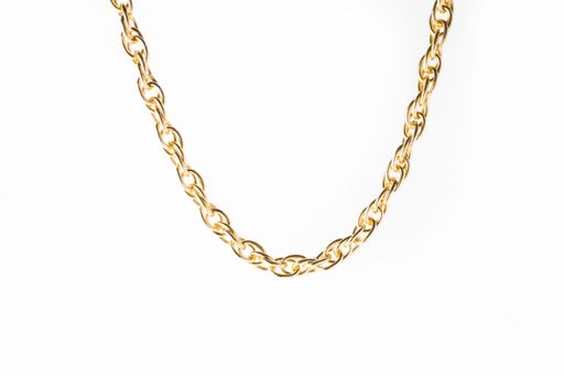A closeup shot of a golden necklace on a white background