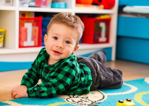 Polish Caucasian toddler boy playing on a carpet