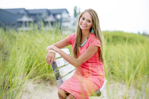 A closeup shot of a beautiful female sitting on the bench while smiling at the camera