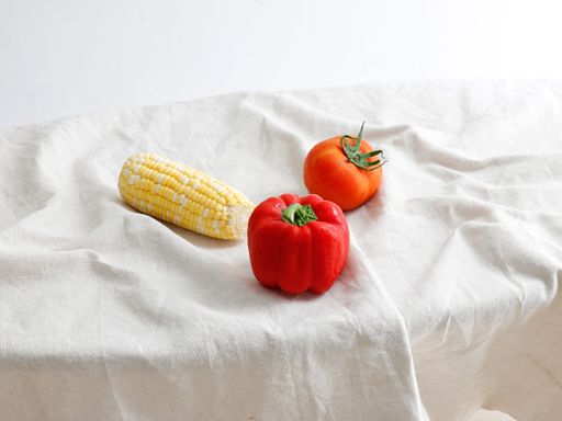 A tomato, pepper and corn on white background