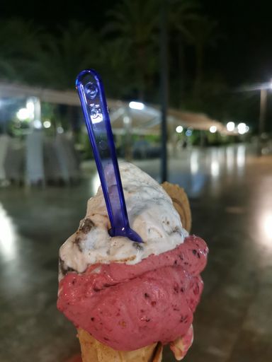A selective focus shot of the delicious ice cream with a blue spoon
