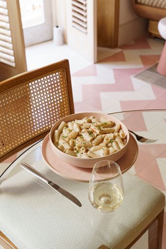 A rose dish of delicious pasta served with white wine