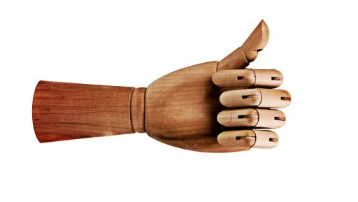 a wooden dummy mannequin hand with a thumb up isolated on white background