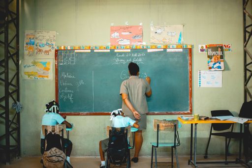 A beautiful shot of children sitting in class while the teacher explaining the lesson