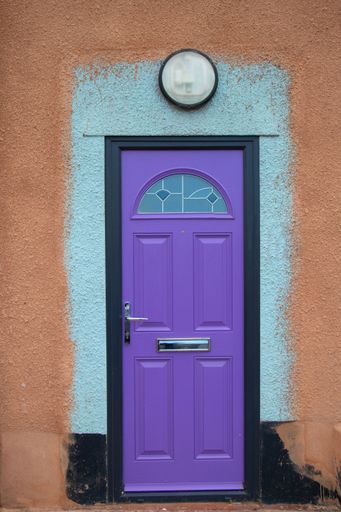 A vertical shot of new bright purple wooden door of old building