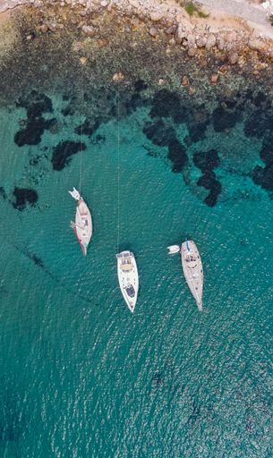 A beautiful aerial view of three moored yachts