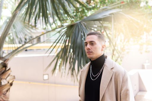 Portrait of a young mixed-race man standing in the park in the city. Lifestyle concept, copy spac