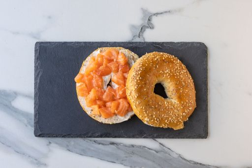A top view of an open cut bagel with delicious meat, vegetables, and sauce
